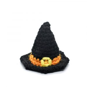 a small crocheted black witch hat with an orange band and a yellow buckle