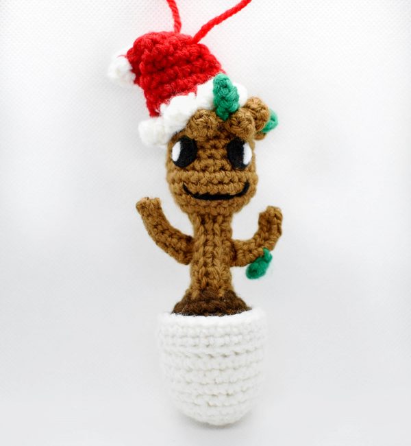 crochet orgnament of baby groot wearing a santa hat