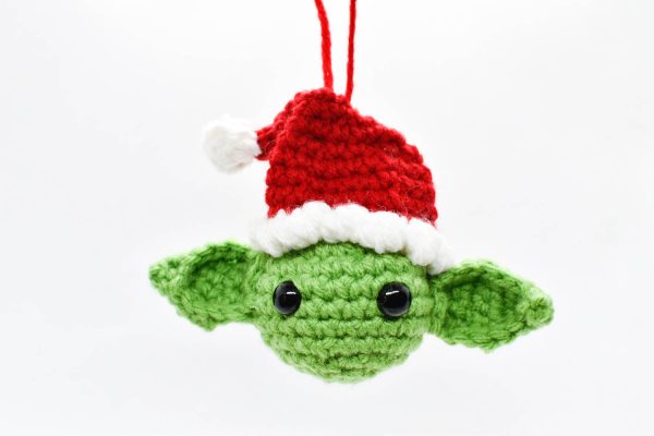 crochet christmas ornament of yoda wearing a santa hat