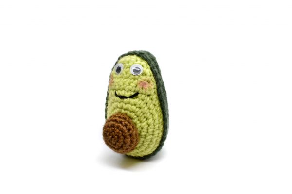crochet avocado doll on white background - partial front view