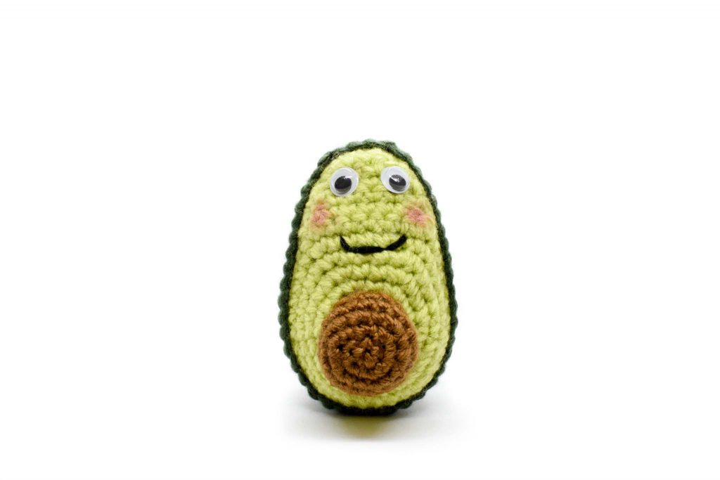 crochet avocado doll on white background - front view