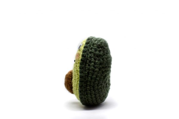 crochet avocado doll on white background - side view