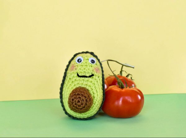 crochet avocado doll next to some real tomatoes