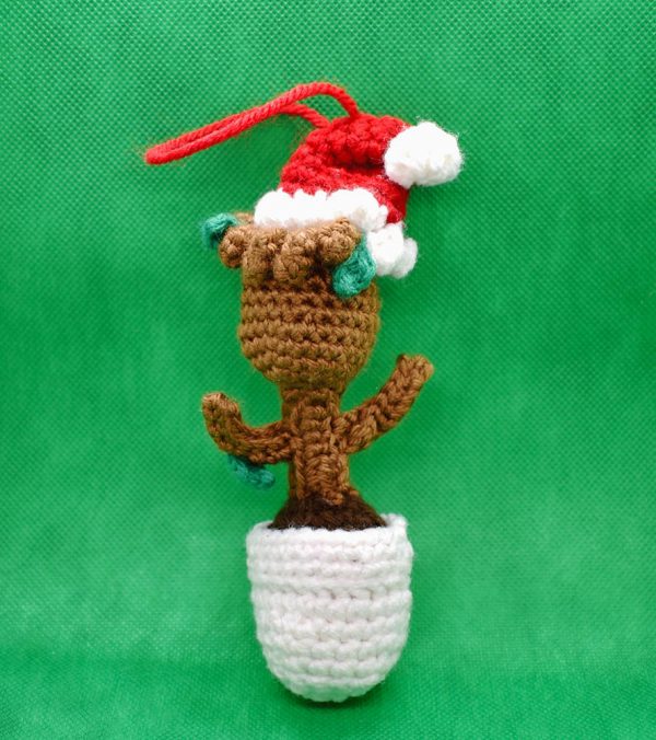 crochet baby groot christmas ornament doll against a green background - back view of doll