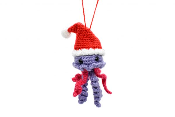 a small crochet jellyfish wearing a Santa hat