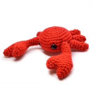 a small crochet crab against a white background