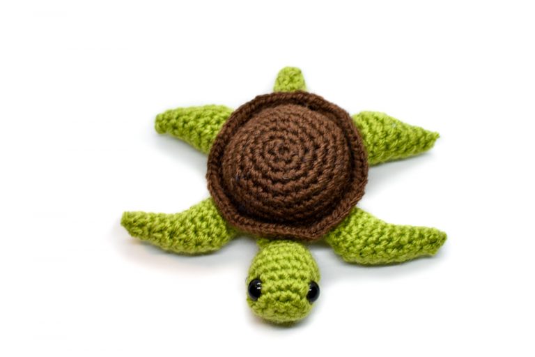 front view of a small crochet sea turtle toy with a white background
