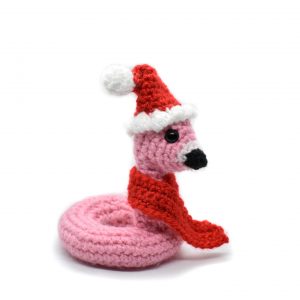 a small crochet flamingo floatie wearing a Santa hat and red scarf