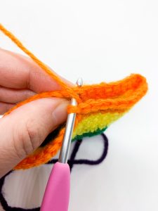 Figure 1: Inserting the crochet hook into the first stitch of the previous round, to split the heart into two humps