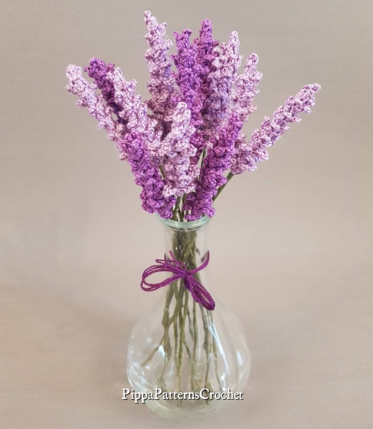 a bouquet of detailed crocheted lavender in a clear round vase
