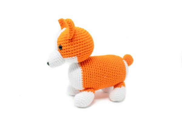 a crochet stuffed corgi dog against a white background