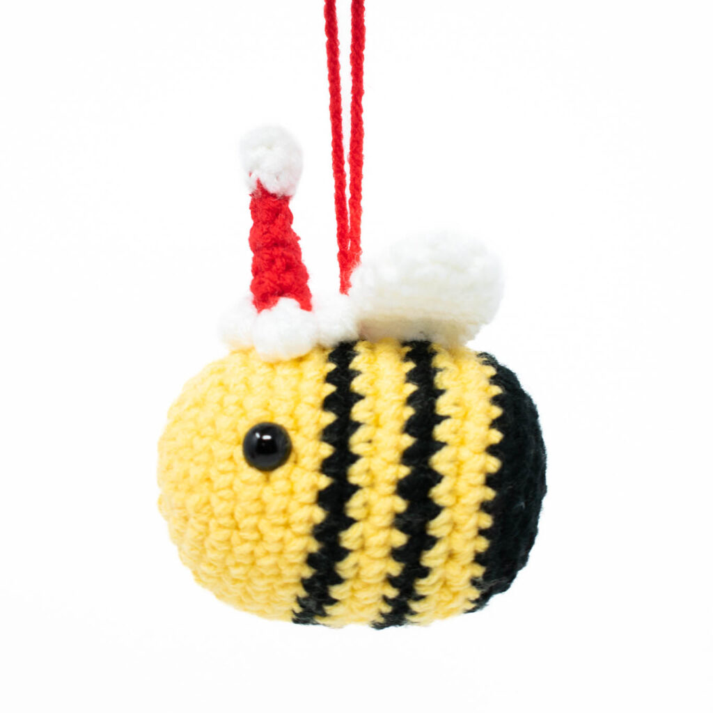 a crochet stuffed bee with a Santa hat